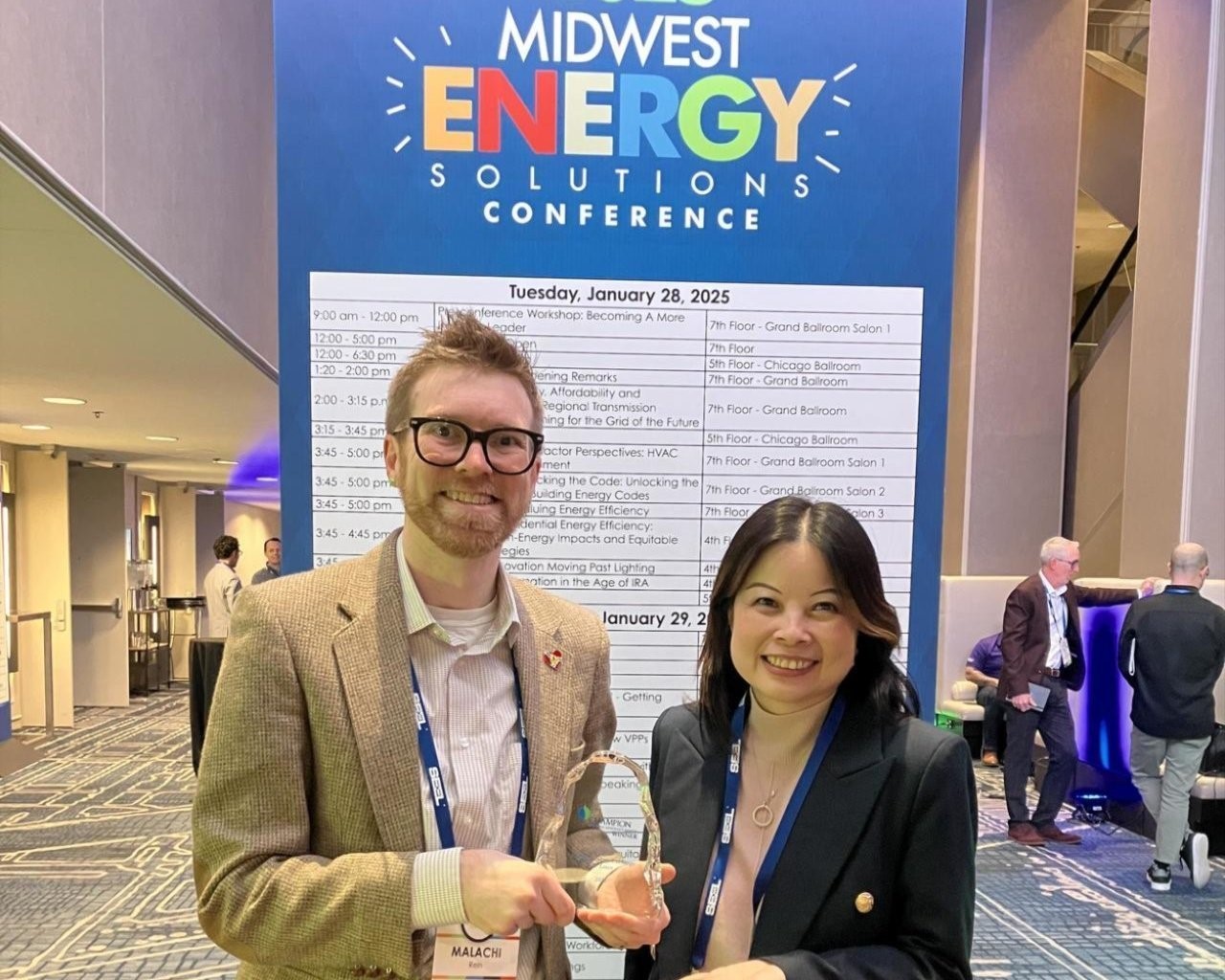Two professionals holding awards at the Midwest Energy Solutions Conference. Two professionals holding awards at the Midwest Energy Solutions Conference.